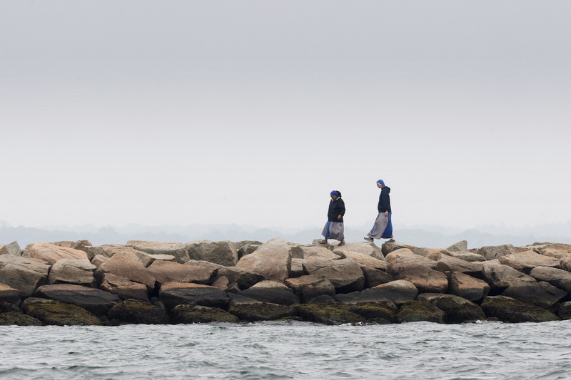 Two nuns walk along a jetty on East Beach in New Bedford, MA on a foggy morning. PHOTO PETER PEREIRA