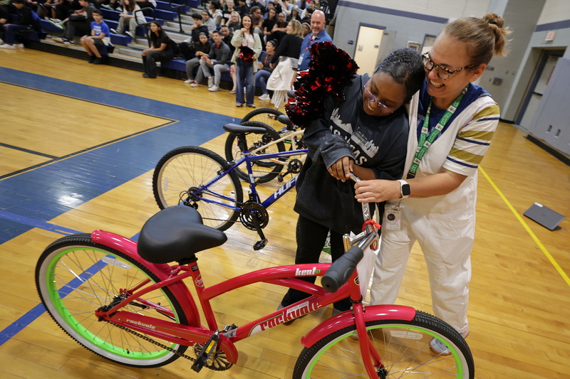Genesis Costa is overcome with emotion as she hugs councilor Patty Keefe upon hearing she had been awarded a bicycle at the Normandin Middle School in New Bedford, MA. Normandin attendance officer Darryle Morris worked with Johnson & Johnson�to secure the bicycles which were awarded as part of the school's effort to recognize and celebrate student progress, attendance, and perseverance. PHOTO PETER PEREIRA