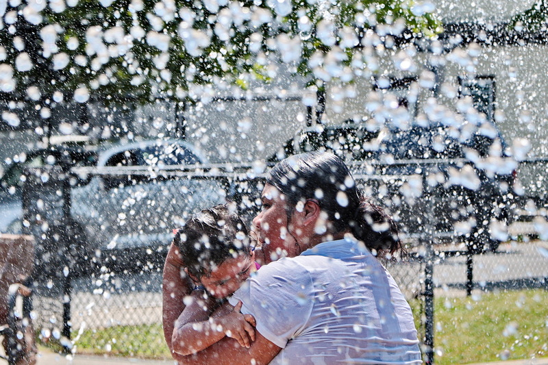 Talia Morales and her daughter Aroleia Morales, 1, cool off from the extreme heat at the Harrington Park water feature in New Bedford, MA.  PHOTO PETER PEREIRA