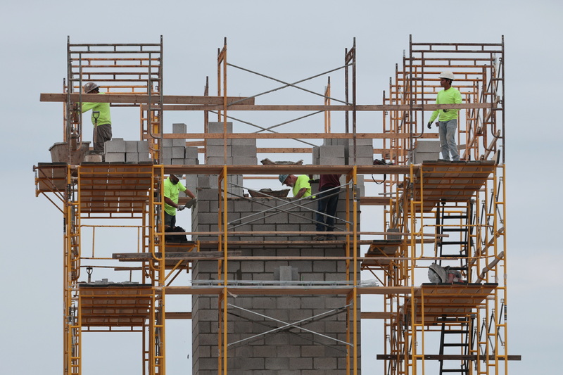 Masons are framed by various apertures in their environment as they construct the elevator shaft for the future residential complex being constructed on Dartmouth Street in Dartmouth, MA.  PHOTO PETER PEREIRA