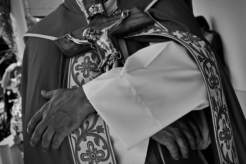Rev Paulo Filipe holds a crucifix close to his chest during the procession of Sao Pedro in Cova-Gala, Portugal.  PHOTO PETER PEREIRA