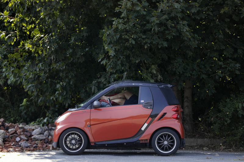 A man relaxes inside his car parked in the shade at Fort Phoenix in Fairhaven, MA. PHOTO PETER PEREIRA