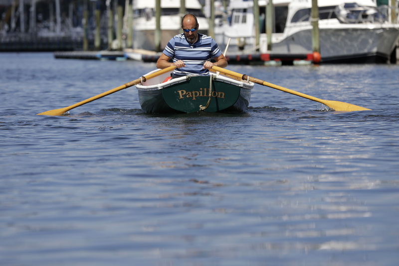 A man rows out into New Bedford harbor aboard his boat Papillon from a boat ramp in Fairhaven, MA. PHOTO PETER PEREIRA