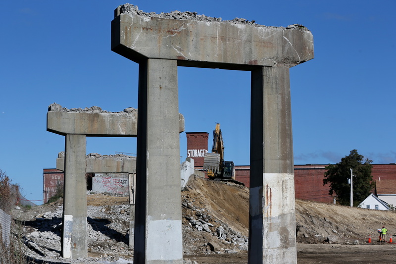 An excavator is visible tearing down parts of the southbound offramp from Route 195 to Route 18, marking the start of the five-year renovation project beneath the highway in New Bedford, MA. PHOTO PETER PEREIRA