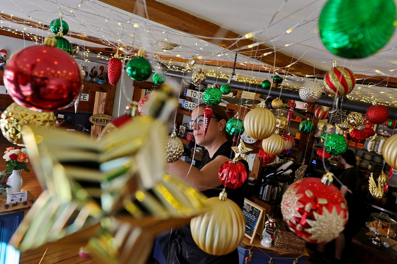 Jessica Arruda, owner of Tia Maria's European Cafe, embraces the festive season by adorning the ceiling of her restaurant on N Water Street in downtown New Bedford, MA with Christmas decorations. PHOTO PETER PEREIRA