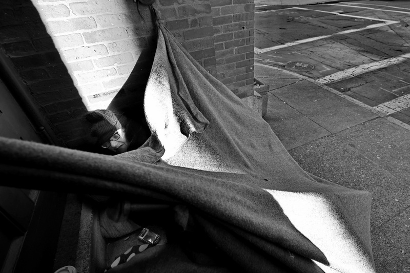 Lilly attempts to keep warm beneath her improvised blanket tent outside the Pilgrim United Church of Christ on Purchase Street in New Bedford, MA while temperatures linger near fifteen degrees (-10C)  on a cold morning.  Lilly has been homeless for a few months and as temperatures continue to fall is becoming worried about her wellbeing. PHOTO PETER PEREIRA