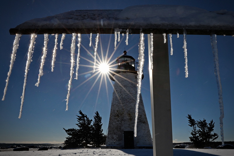 On a chilly morning in Mattapoisett, MA icicles hang from the information board that details the history of the Ned's Point lighthouse visible in the distance. PHOTO PETER PEREIRA