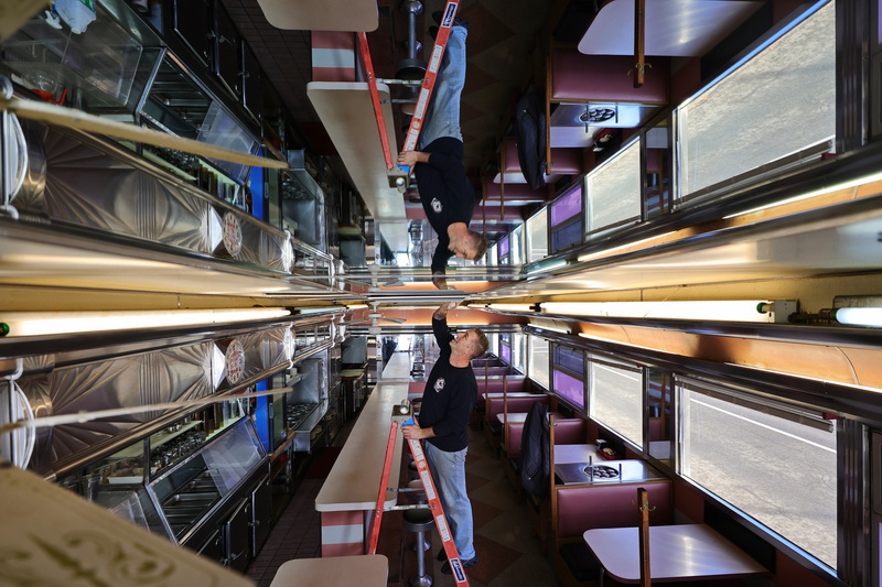 Kevin Carvalho cleans the mirrored ceiling of the Angelo's Orchid Diner on Rockdale Avenue in New Bedford, MA in preparation for the iconic diner to be put up for sale.  Mr. Carvalho's parents Angelo and Geraldine currently own the diner and are ready to sell it. PHOTO PETER PEREIRA
