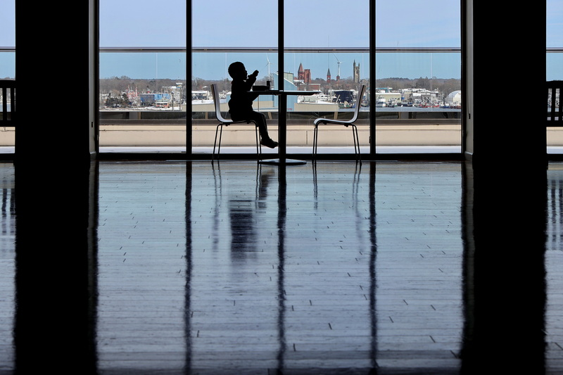 The iconic Fairhaven skyline is seen in the distance as a young boy enjoys lunch with a view in the Harborview gallery at the New Bedford Whaling Museum. PHOTO PETER PEREIRA