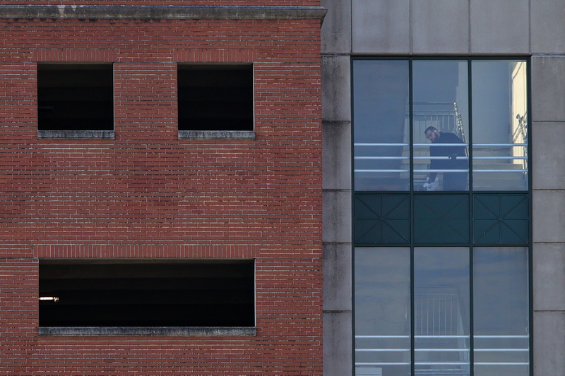 The Zeiterion Theater parking garage appears happy as a parking attendant cleans the windows of its stairwell in downtown New Bedford, MA. PHOTO PETER PEREIRA