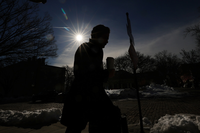 A man makes his way up William Street with a warm  cup of coffee in his hand as the sun rises in the distance on a frigid morning in New Bedford, MA. PHOTO PETER PEREIRA