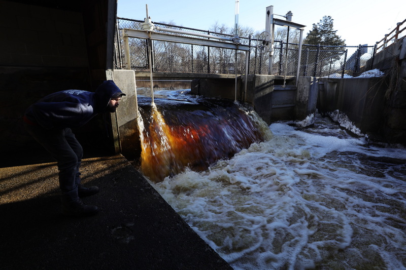 John Lanczycki from the Mattapoisett Water Department looks downstream to see if he can spot some herring after opening the dam and removing the boards from the herring ladder (to the right of the dam) in Mattapoisett, allowing water to flow down the steps that the herring use to travel upstream in the Mattapoisett River. PHOTO PETER PEREIRA