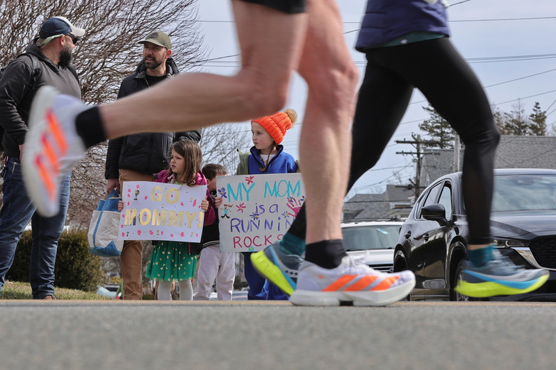 Hazel Cate and Delilah Freshman seek their moms with signs of encouragement during the 2026 New Bedford Half Marathon. PHOTO PETER PEREIRA