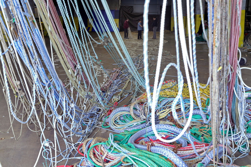 Fishermen from the F/V Enterprise make repairs to their herring/mackerel net inside of the State Pier hanger in New Bedford, MA.  PHOTO PETER PEREIRA