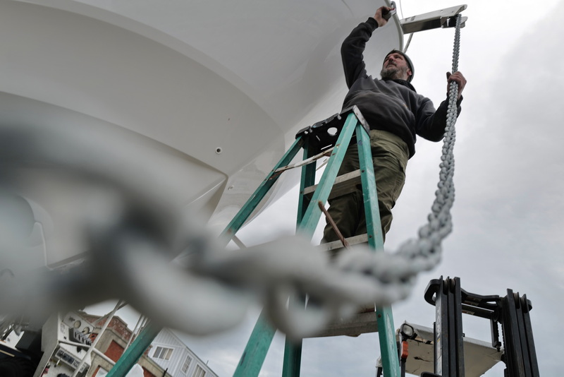 Doug Lemieux hoists a chain with anchor as he prepares a new yacht sold by Cape Yachts in Dartmouth, MA before it is picked up by the owner at South Wharf Yacht Yard & Marina.  PHOTO PETER PEREIRA
