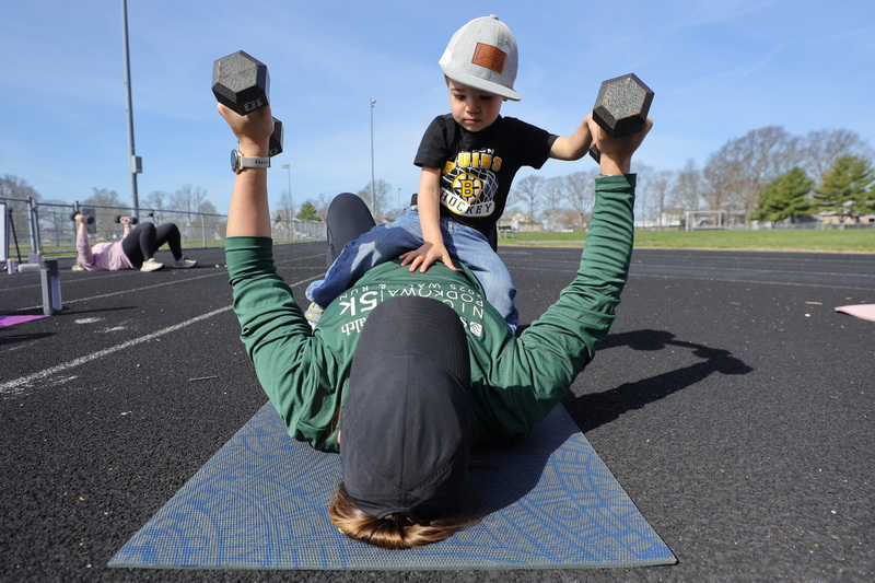 Lucas Bairos, 2, attempts to assist his mother, Courtney Bairos, in lifting weights during a weekly iStroll Southcoast workout held at Cushman Park in Fairhaven, MA.  PHOTO PETER PEREIRA