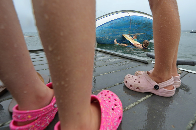 On a rainy day, young sailors enrolled in the two week William E. Mee Youth Sailing program with the Mattapoisett Community Sailing Association perform capsize drills off the dock in Mattapoisett, MA on their first day of the program on July 7, 2026. PHOTO PETER PEREIRA