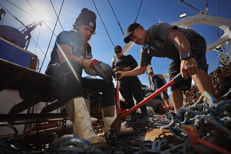 Fisherman aboard a scalloper fishing boat docked in New Bedford, MA make repairs to the dredges before heading back out to sea on July 20, 2026. PHOTO PETER PEREIRA