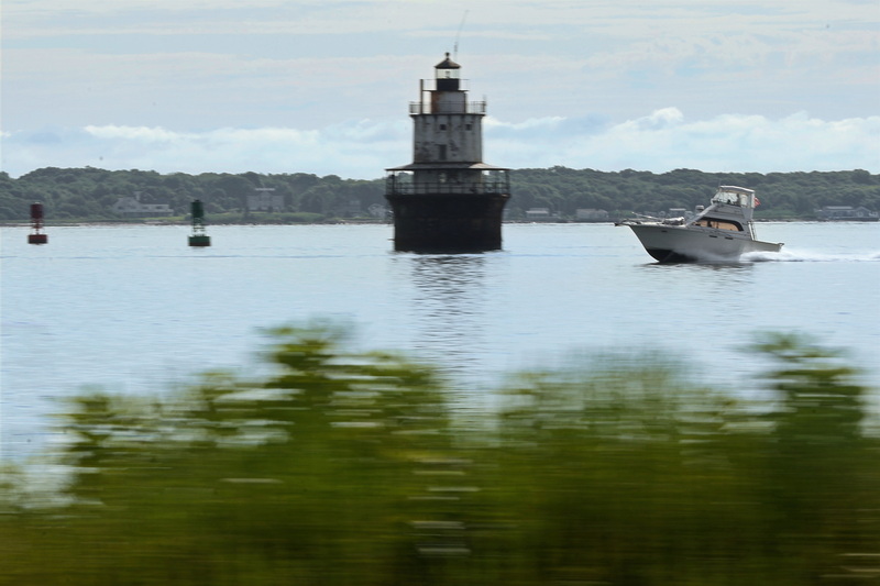 A powerboat streaks across Buzzards Bay past the Butler Flats lighthouse making its way into New Bedford harbor on July 27, 2026. PHOTO PETER PEREIRA