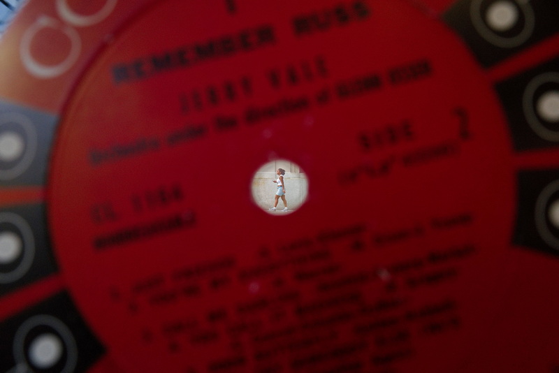 On August 28, 2026, a woman strolling along Pleasant Street in New Bedford, MA, is visible through the hole of a vinyl record showcased in the window of Record High�s recently opened store at the corner of Pleasant Street and Union Street. PHOTO PETER PEREIRA