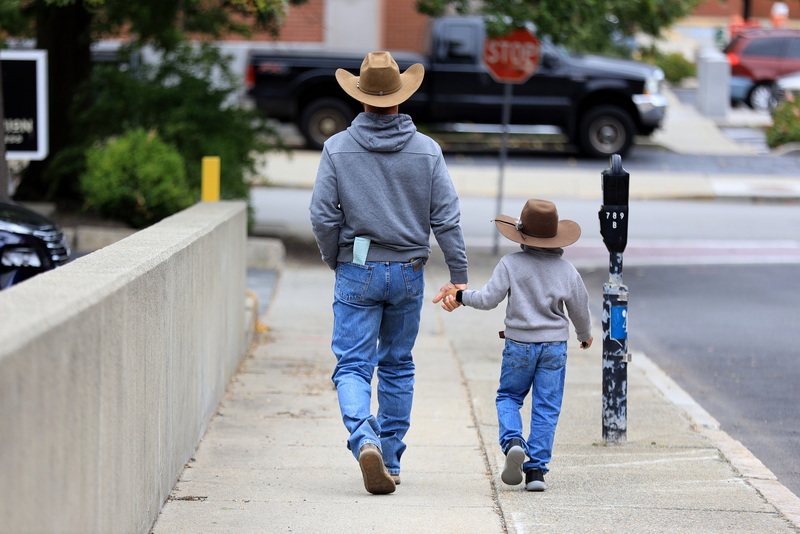 A man and young boy with cowboy hats walk down Spring Street in New Bedford, MA on September 25, 2026 during a visit to the city. PHOTO PETER PEREIRA