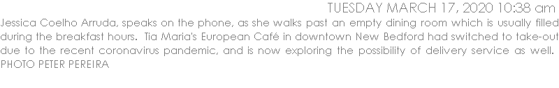 Jessica Coelho Arruda, speaks on the phone, as she walks past an empty dining room which is usually filled during the breakfast hours.  Tia Maria's European Caf in downtown New Bedford had switched to take-out due to the recent coronavirus pandemic, and is now exploring the possibility of delivery service as well.  PHOTO PETER PEREIRA