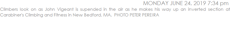 Climbers look on as John Vigeant is supended in the air as he makes his way up an inverted section at Carabiner's Climbing and Fitness in New Bedford, MA.  PHOTO PETER PEREIRA