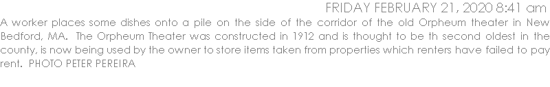 A worker places some dishes onto a pile on the side of the corridor of the old Orpheum theater in New Bedford, MA.  The Orpheum Theater was constructed in 1912 and is thought to be th second oldest in the county, is now being used by the owner to store items taken from properties which renters have failed to pay rent.  PHOTO PETER PEREIRA