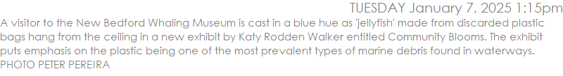 A visitor to the New Bedford Whaling Museum is cast in a blue hue as 'jellyfish' made from discarded plastic bags hang from the ceiling in a new exhibit by Katy Rodden Walker entitled Community Blooms. The exhibit puts emphasis on the plastic being one of the most prevalent types of marine debris found in waterways.  PHOTO PETER PEREIRA
