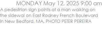 A pedestrian sign points at a man walking on the sidewal on East Rodney French Boulevard in New Bedford, MA. PHOTO PETER PEREIRA