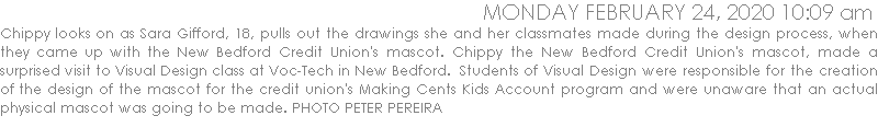 Chippy looks on as Sara Gifford, 18, pulls out the drawings she and her classmates made during the design process, when they came up with the New Bedford Credit Union's mascot. Chippy the New Bedford Credit Union's mascot, made a surprised visit to Visual Design class at Voc-Tech in New Bedford.  Students of Visual Design were responsible for the creation of the design of the mascot for the credit union's Making Cents Kids Account program and were unaware that an actual physical mascot was going to be made.  PHOTO PETER PEREIRA
