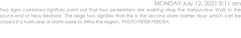 Two signs combined rightfully point out that two pedestrians are walking atop the Harborview Walk in the sound end of New Bedford.  The large two signifies that this is the second storm barrier door which can be closed if a hurricane or storm were to strike the region.  PHOTO PETER PEREIRA