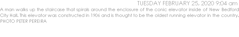 A man walks up the staircase that spirals around the enclosure of the conic elevator inside of New Bedford City Hall. This elevator was constructed in 1906 and is thought to be the oldest running elevator in the country. 