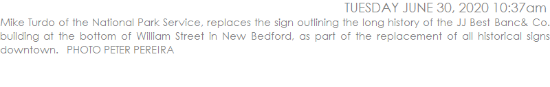 Mike Turdo of the National Park Service, replaces the sign outlining the long history of the JJ Best Banc& Co. building at the bottom of William Street in New Bedford, as part of the replacement of all historical signs downtown.   PHOTO PETER PEREIRA