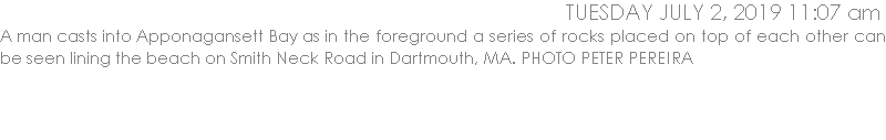 A man casts into Apponagansett Bay as in the foreground a series of rocks placed on top of each other can be seen lining the beach on Smith Neck Road in Dartmouth, MA. PHOTO PETER PEREIRA