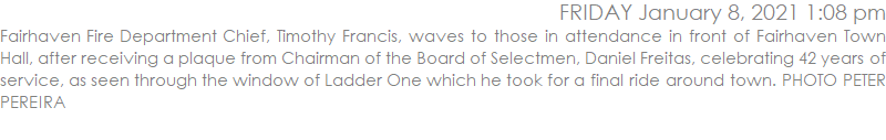 Fairhaven Fire Department Chief, Timothy Francis, waves to those in attendance in front of Fairhaven Town Hall, after receiving a plaque from Chairman of the Board of Selectmen, Daniel Freitas, celebrating 42 years of service, as seen through the window of Ladder One which he took for a final ride around town. PHOTO PETER PEREIRA