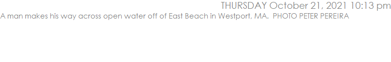 A man makes his way across open water off of East Beach in Westport, MA.  PHOTO PETER PEREIRA