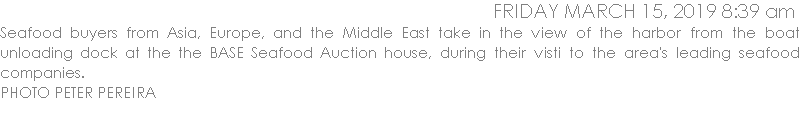 Seafood buyers from Asia, Europe, and the Middle East take in the view of the harbor from the boat unloading dock at the the BASE Seafood Auction house, during their visti to the area's leading seafood companies. 