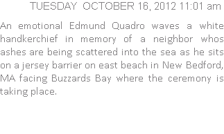 An emotional Edmund Quadro waves a white handkerchief in memory of a neighbor whos ashes are being scattered into the sea as he sits on a jersey barrier on east beach in New Bedford, MA facing Buzzards Bay where the ceremony is taking place.