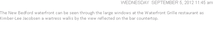  The New Bedford waterfront can be seen through the large windows at the Waterfront Grille restaurant as Kimber-Lee Jacobsen a waitress walks by the view reflected on the bar countertop.