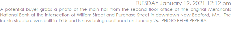 A potential buyer grabs a photo of the main hall from the second floor office of the original Merchants National Bank at the intersection of William Street and Purchase Street in downtown New Bedford, MA.  The iconic structure was built in 1915 and is now being auctioned on January 26.  PHOTO PETER PEREIRA