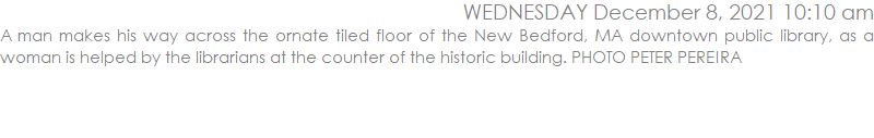 A man makes his way across the ornate tiled floor of the New Bedford, MA downtown public library, as a woman is helped by the librarians at the counter of the historic building. PHOTO PETER PEREIRA