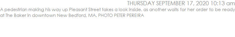 A pedestrian making his way up Pleasant Street takes a look inside, as another waits for her order to be ready at The Baker in downtown New Bedford, MA. PHOTO PETER PEREIRA