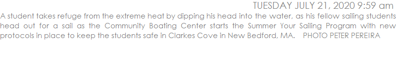 A student takes refuge from the extreme heat by dipping his head into the water, as his fellow sailing students head out for a sail as the Community Boating Center starts the Summer Your Sailing Program with new protocols in place to keep the students safe in Clarkes Cove in New Bedford, MA