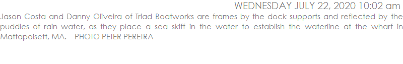 Jason Costa and Danny Oliveira of Triad Boatworks are frames by the dock supports and reflected by the puddles of rain water, as they place a sea skiff in the water to establish the waterline at the wharf in Mattapoisett, MA.    PHOTO PETER PEREIRA