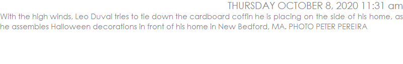 With the high winds, Leo Duval tries to tie down the cardboard coffin he is placing on the side of his home, as he assembles Halloween decorations in front of his home in New Bedford, MA. PHOTO PETER PEREIRA