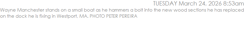 Wayne Manchester stands on a small boat as he hammers a bolt into the new wood sections he has replaced on the dock he is fixing in Westport, MA. PHOTO PETER PEREIRA
