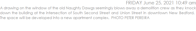 A drawing on the window of the old Naughty Dawgs seemingly blows away a demolition crew as they knock down the building at the intersection of South Second Street and Union Street in downtown New Bedford.  The space will be developed into a new apartment complex.  PHOTO PETER PEREIRA
