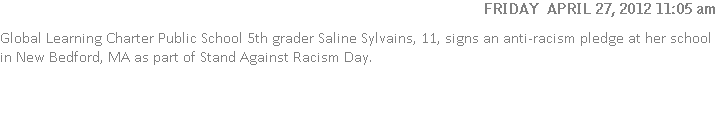 Global Learning Charter Public School 5th grader Saline Sylvains, 11, signs an anti-racism pledge at her school in New Bedford, MA as part of Stand Against Racism Day.