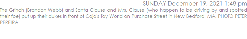 The Grinch (Brandon Webb) and Santa Clause and Mrs. Clause (who happen to be driving by and spotted their foe) put up their dukes in front of Cojo's Toy World on Purchase Street in New Bedford, MA. PHOTO PETER PEREIRA